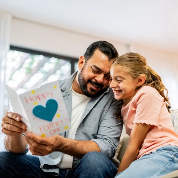 Dad reading a heartfelt handwritten Father's Day card from his daughter