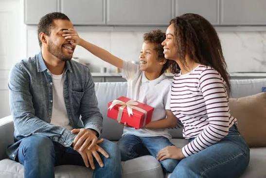 Family celebrating Father's Day together at home with a wrapped gift