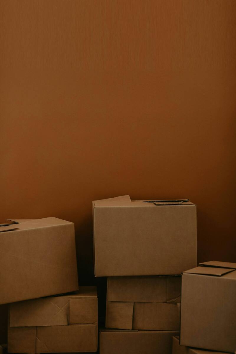 Stack of unmarked cardboard boxes, representing a bulk custom phone case order ready for a team or event
