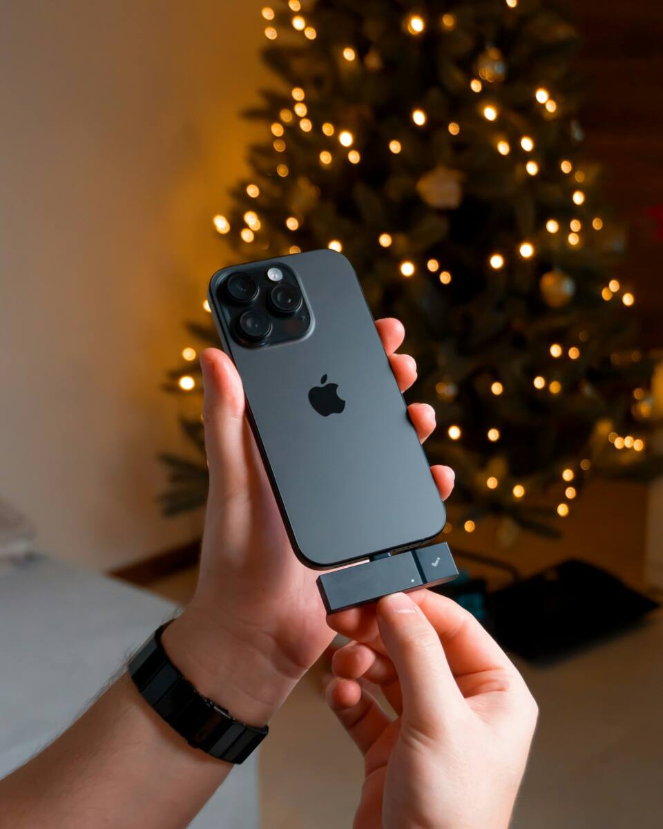 Holding a custom Christmas phone case near a decorated tree
