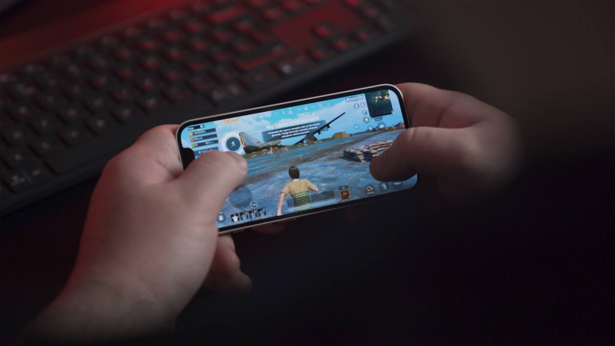 Hands holding a phone displaying a competitive mobile game, representing an esports gaming phone case