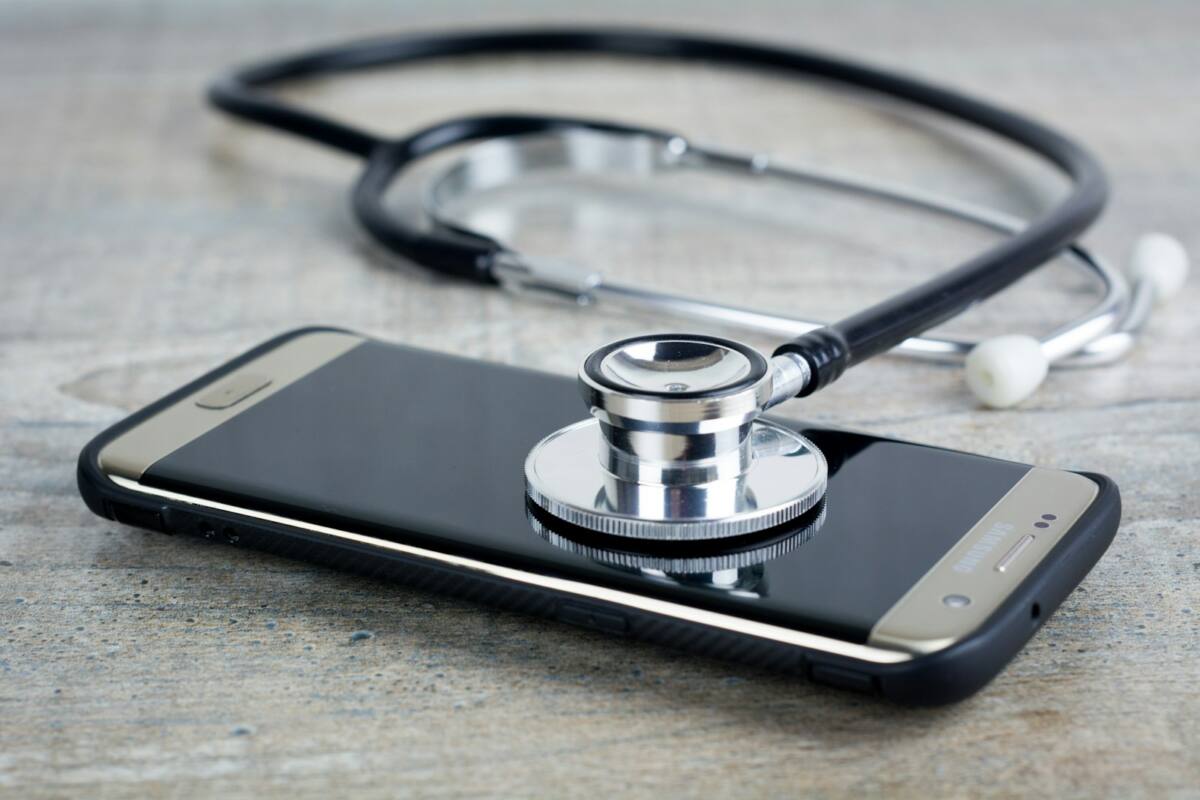 A nurse phone case gift resting next to a stethoscope on a wood table