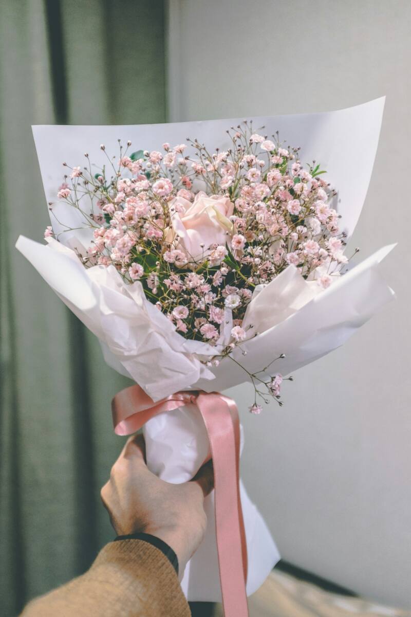 A bouquet of pink roses wrapped in paper, a classic Valentine's Day gift compared to a custom phone case